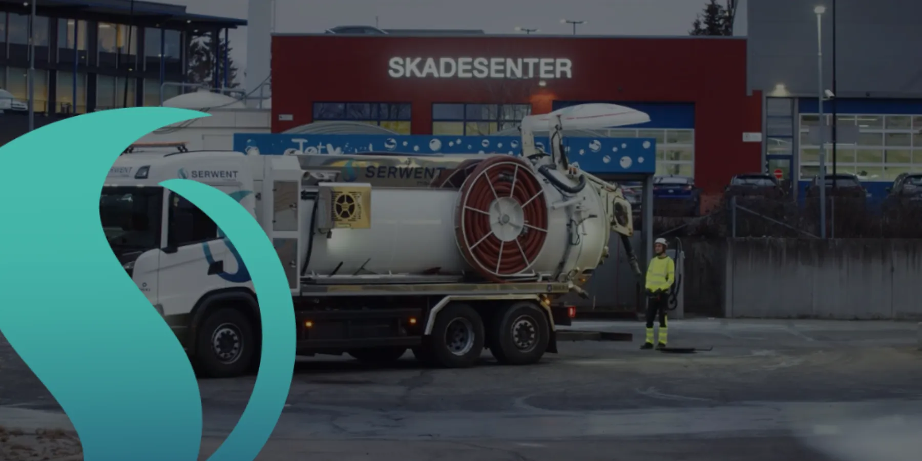 Serwent-slamsugningsvogn og servicebil parkeret foran et Skadesenter – kloakservice med professionelt udstyr
