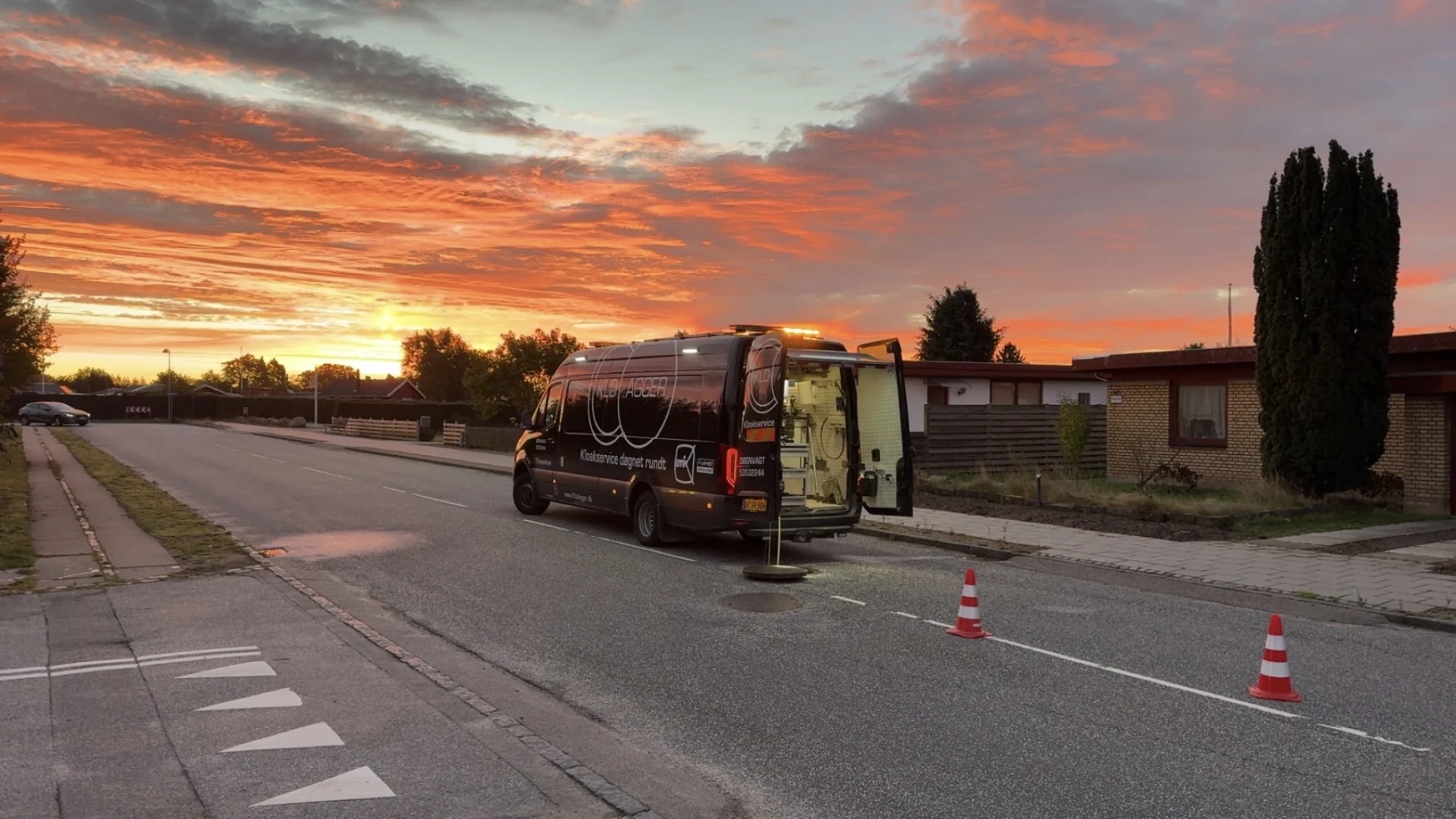 KloAgger servicebil parkeret på villavej under TV-inspektion af kloak i aftensol